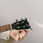 close-up of a hand tuning a guitar
