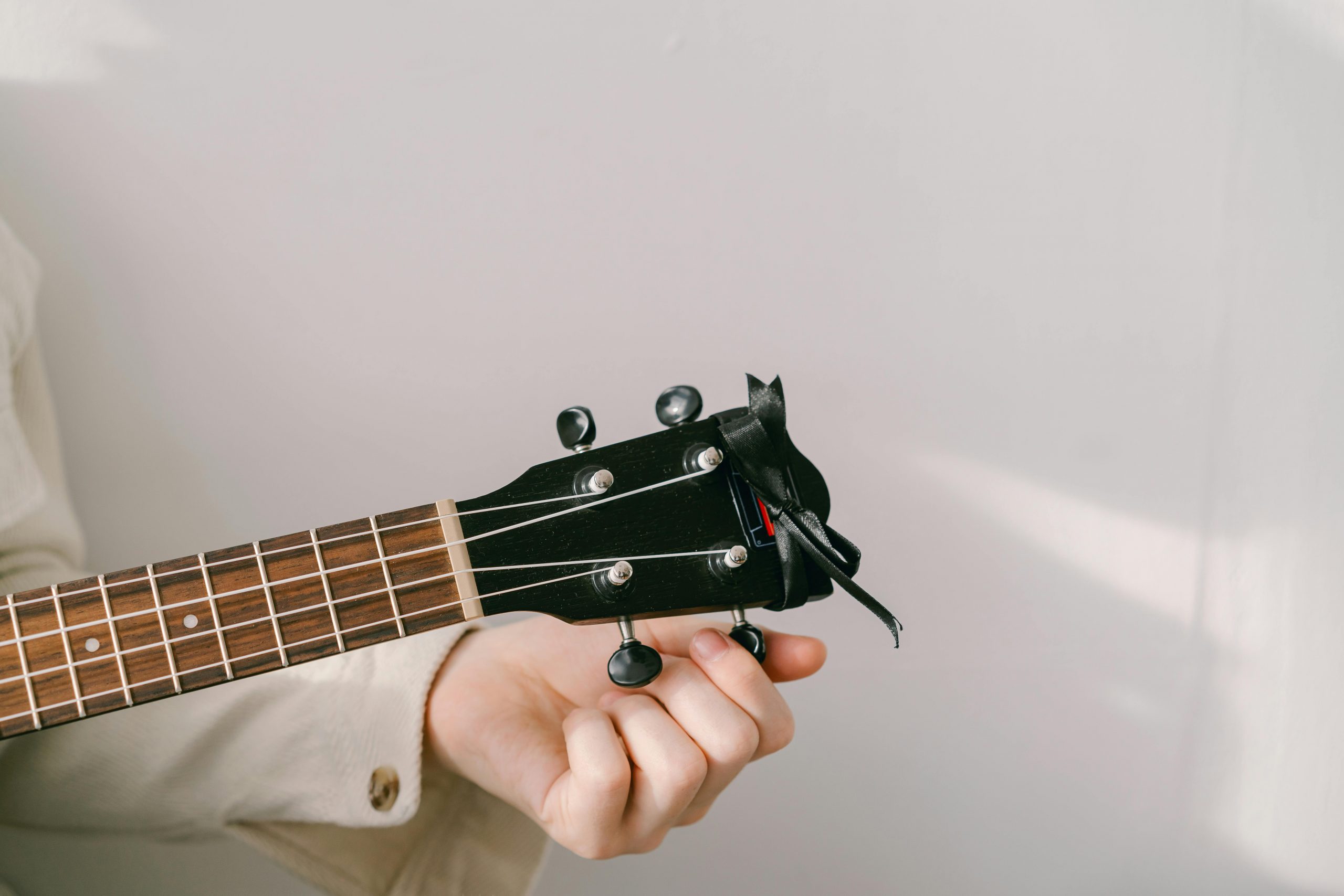 close-up of a hand tuning a guitar